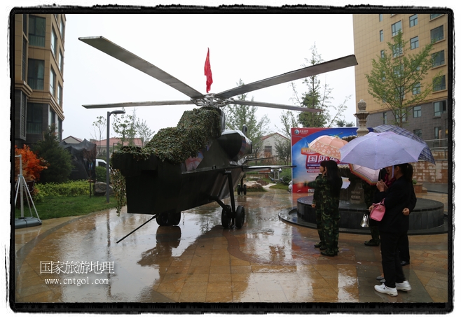 小區(qū)突然出現(xiàn)“飛機(jī)坦克”，其中殲15艦載戰(zhàn)斗機(jī)一架、99式主戰(zhàn)坦克一輛、武直-10武裝直升機(jī)一架，吸引了眾多市民雨中圍觀、合影。